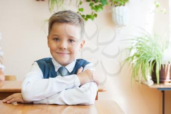 The first time in first class: happy schoolboy at school background