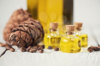 Oil of cedar nuts on a white wooden background