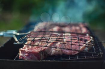 Grilling pork entrecote meat on a grill