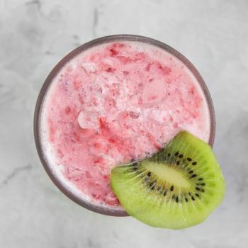 Strawberry smoothie with kiwi on a white concrete background. Square cropping