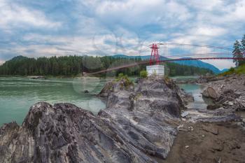 suspension bridge on mountain river Katun in Altai