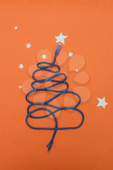 Tech New Year: fir-tree from wires on orange background