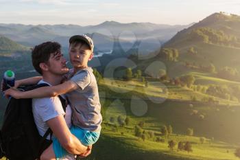 Happy father and son are walking in the Altai mountains