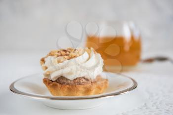 Tasty mini cake with tea on a white background