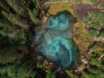 Beautiful Geyser (blue, silver) lake with thermal springs that periodically throw blue clay and silt from the ground. Aerial drone view. Aktash, Altai mountains, Russia