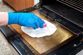 Royalty Free Photo of a Person Cleaning a Kitchen Oven