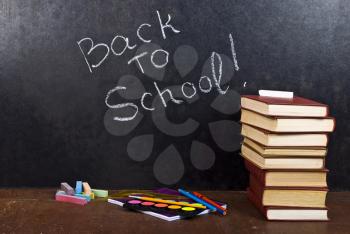 Royalty Free Photo of Back to School Written on Chalkboard With Books