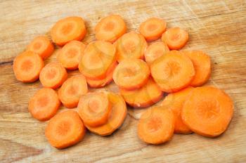 Fresh carrot slices on wooden chopping board