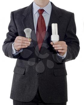 Businessman with old and energy-saving light bulbs isolated on the white