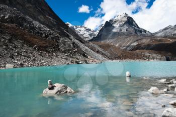 Pebble stacks and Sacred Lake near Gokyo in Himalayas