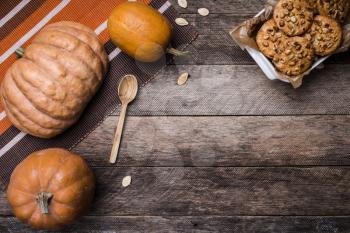 Pumpkins and tasty cookies with nuts on wooden table. Autumn Season food photo
