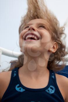 Portrait of cute little girl laughing with her hair blown in the wind.