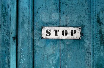 close up of a sign saying 'stop'on the grunge wooden background
