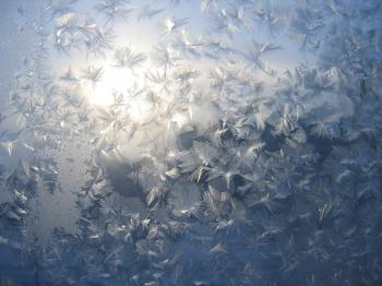 frosty natural pattern and sun on winter glass