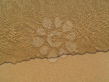 Transparent sea wave on the sand closeup background                               