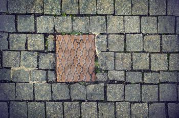 Paving stones background with rusty metal plate