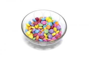 Bright colorful candy in glass bowl isolated on white background