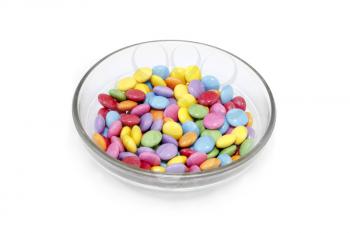 Bright colorful candy in glass bowl isolated on white background