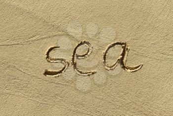 Closeup of natural sand background with scrawled word ''Sea''