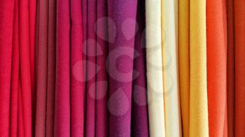 Bright multicolored background of fabrics, close-up texture
