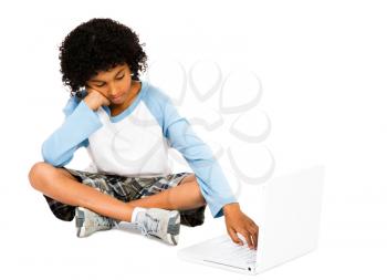 Royalty Free Photo of a Boy Sitting Cross Legged Typing on a Laptop