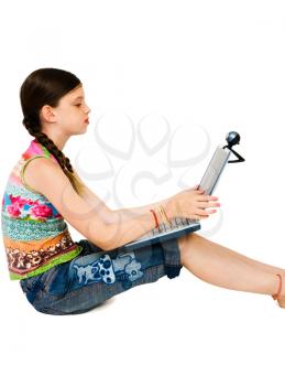 Royalty Free Photo of a Young Girl Sitting Down Working on her Laptop