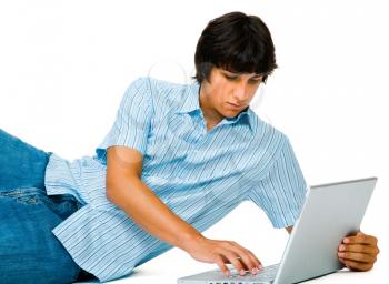 Royalty Free Photo of a Man Lying on the Floor Using a Laptop