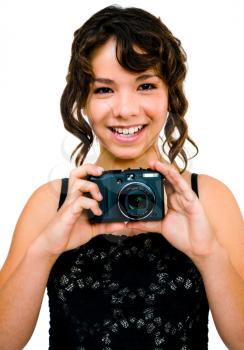 Smiling teenage girl photographing with a camera and posing isolated over white