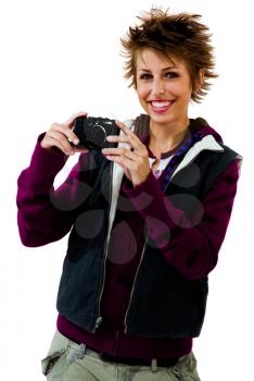 Happy young woman photographing with a camera isolated over white