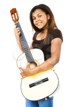 Smiling girl playing a guitar isolated over white
