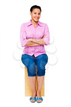 Fashion model sitting on a stool isolated over white