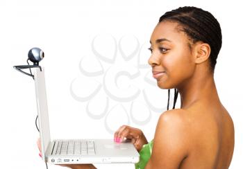 Close-up of a teenage girl using a laptop and smiling isolated over white