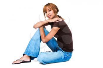 Happy young woman sitting on the floor isolated over white
