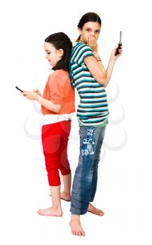 Two girls text messaging on mobile phones isolated over white