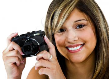 Close-up of a young woman photographing with a camera isolated over white