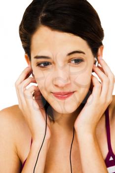 Happy woman listening to music on earbud isolated over white