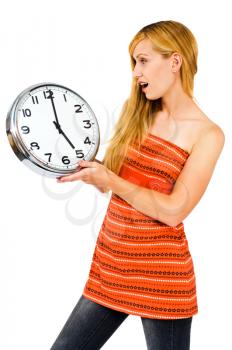 Surprised young woman holding a clock isolated over white