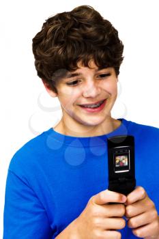 Smiling boy text messaging on a mobile phone isolated over white