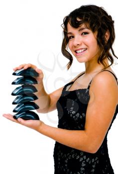 Latin American teenage girl holding a stack of computer mouses and looking happy isolated over white