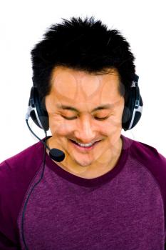 Chinese man wearing headset and listening to music isolated over white