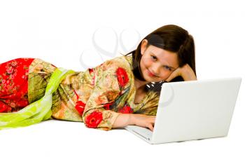 Smiling girl using a laptop and posing isolated over white