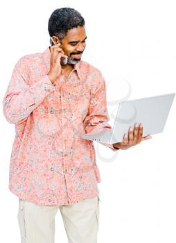 Mature man using a laptop and a mobile isolated over white