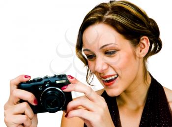 Smiling teenage girl photographing with a camera isolated over white