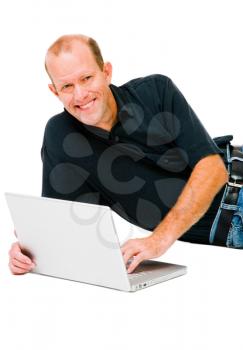 Confident man lying and using a laptop isolated over white