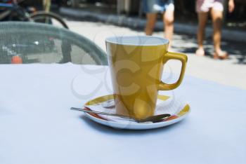 Coffee cup on a table at a sidewalk cafe, Athens, Greece