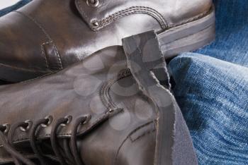 Close-up of a pair of leather boots with jeans