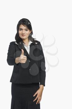 Portrait of a businesswoman showing thumbs-up sign