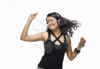 Young woman listening to music and dancing