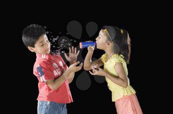 Girl blowing bubbles towards a boy