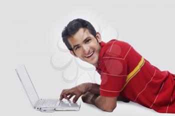 Portrait of a man using a laptop and smiling